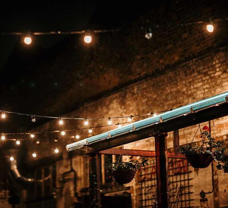 Outdoor reception decor with foliage details and festoon lighting for a city celebration