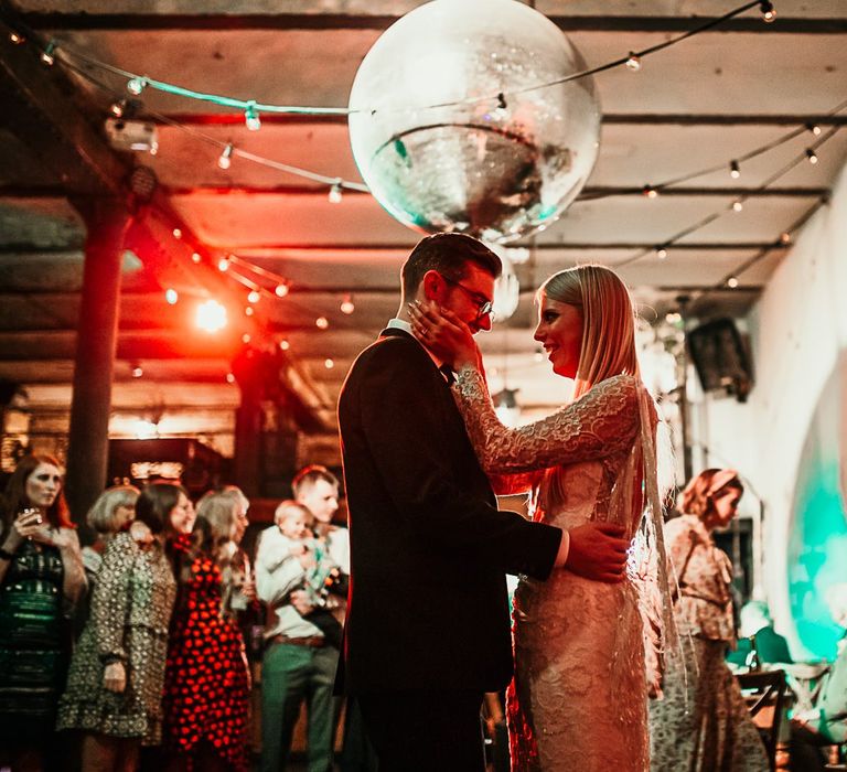 Bride and grooms first dance with festoon lighting and disco ball decor