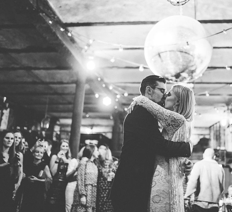 Bride and grooms first dance with festoon lighting and disco ball decor