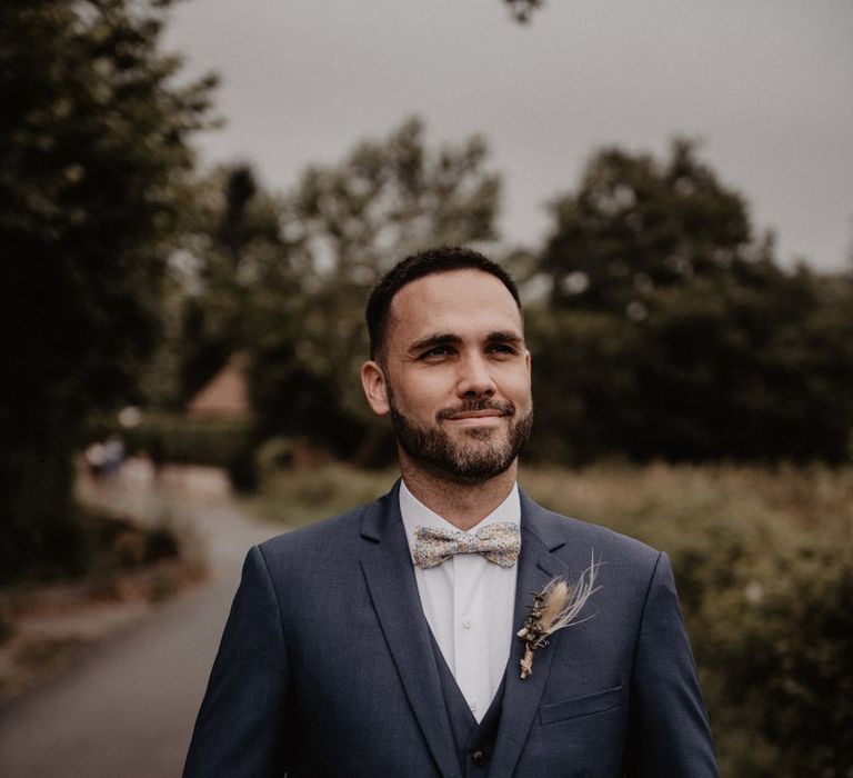 Grooms bow ties and blue wedding suit