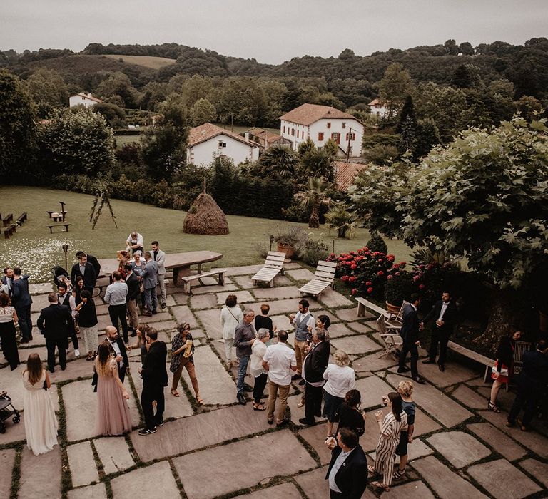 Guests enjoy drinks outdoors at French wedding venue