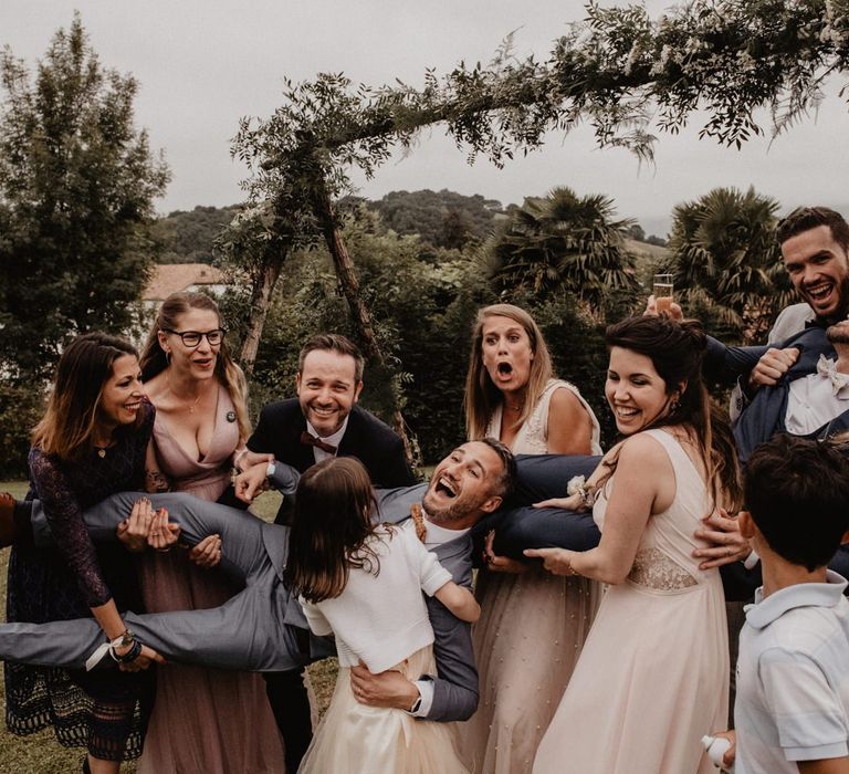 Guests pose under wedding arch