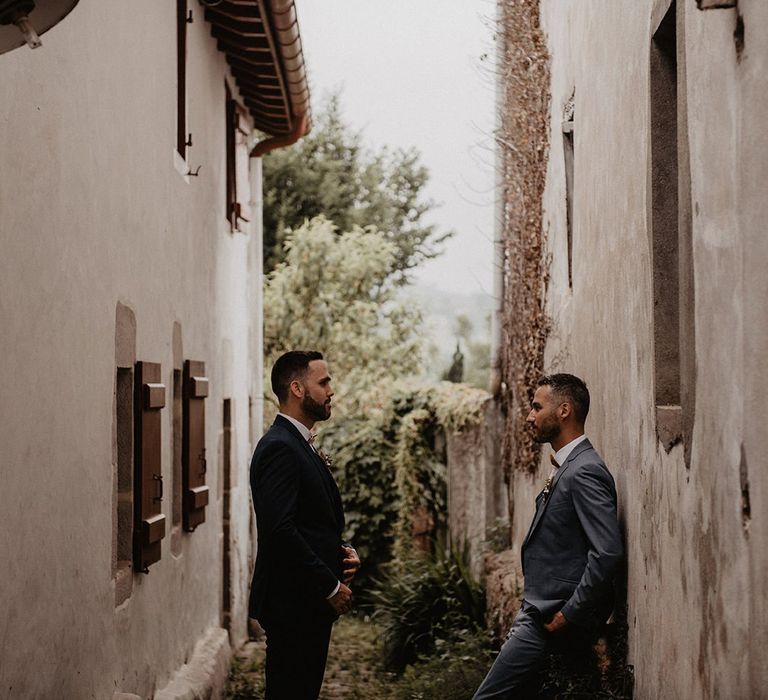 Grooms in bow ties take a moment before ceremony