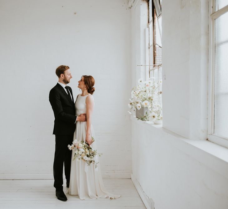 Bride in KATYA KATYA wedding dress and groom in black suit for minimalist wedding