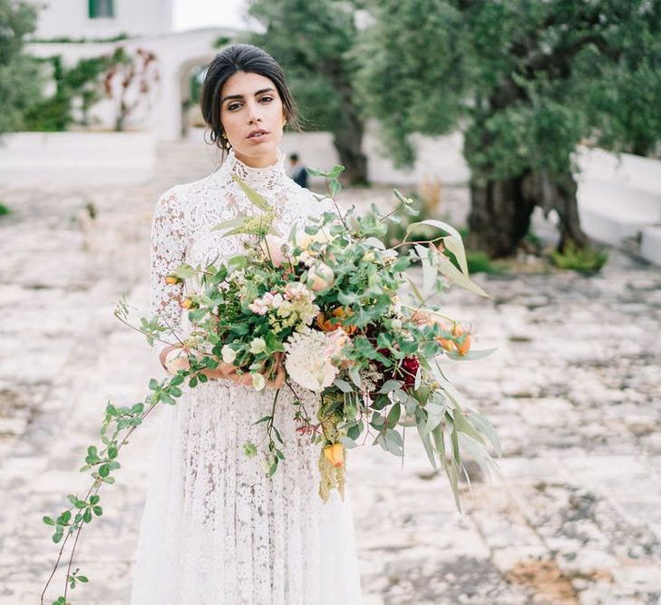 Bride in Lace Andrea Sedici Wedding Dress Holding an Oversized Romantic Wedding Bouquet