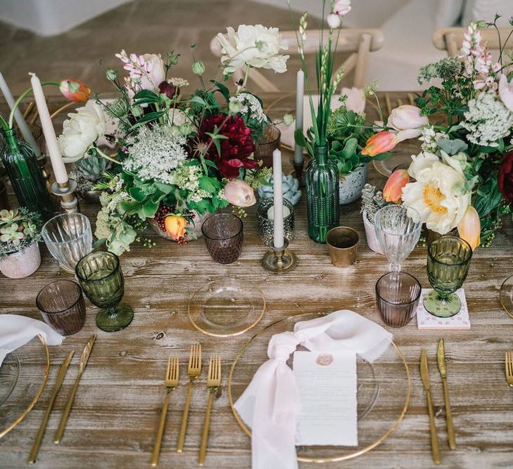 Elegant Tablescape with Gold Charger Plate and Cutlery and Lots of Flowers in Vases