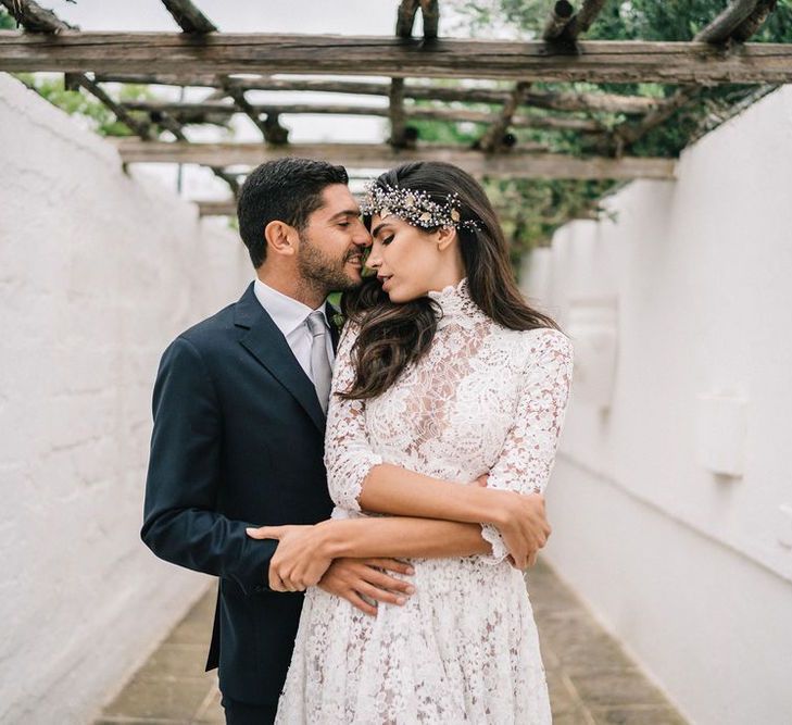 Bride in Lace Wedding Dress and Hair Accessory and Groom in Dark Suit