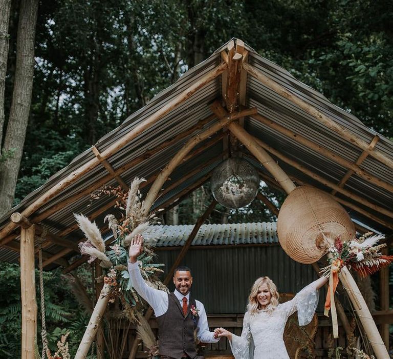 Bride and Groom Waving at the Altar in Lace Wedding Dress and Wool Suit