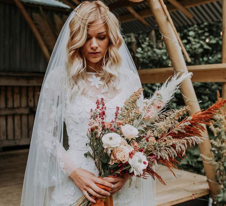 Boho Bride in Lace Wedding Dress Holding a Natural Wedding Bouquet with Roses and Pampas Grass