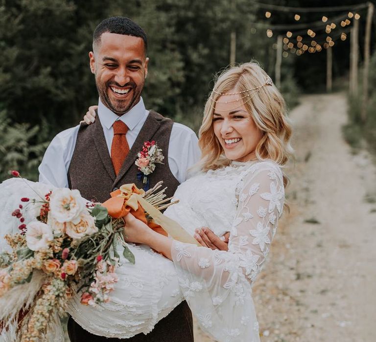 Groom in Wool Waistcoat Holding His Bride in an Applique Wedding Dress