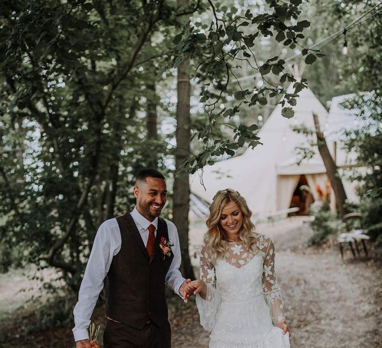 Boho Bride in Applique Wedding Dress with Long Sleeves and Groom in Wool Waistcoat Holding a Bouquet