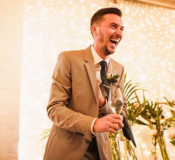 Groom laughs at wedding speeches