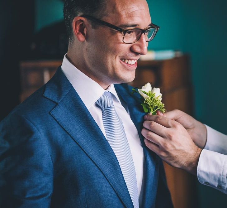 Groom getting ready for same-sex intimate city celebration in East London  wearing a navy blazer