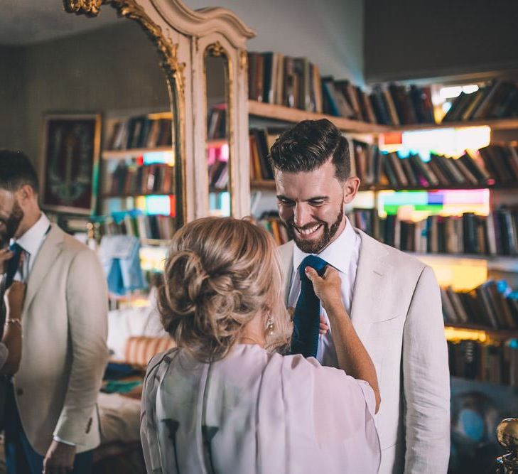 Groom getting ready for same-sex intimate city celebration in East London  wearing a white blazer