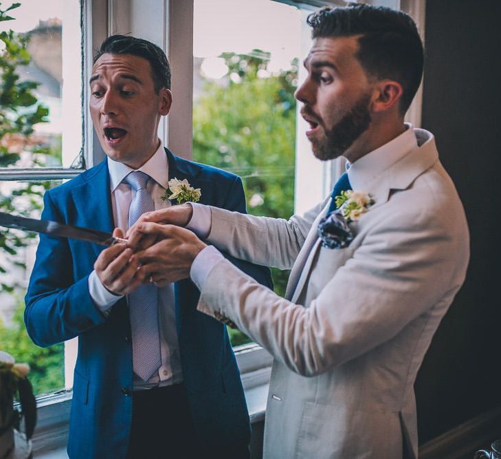 Grooms cut the semi-naked cake for intimate gay wedding in London