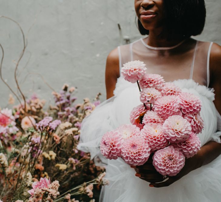 Bride holding a pink pompom wedding bouquet