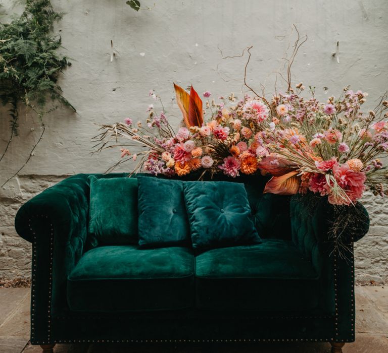 Green velvet sofa and pink wedding flowers at Secret Garden Kent