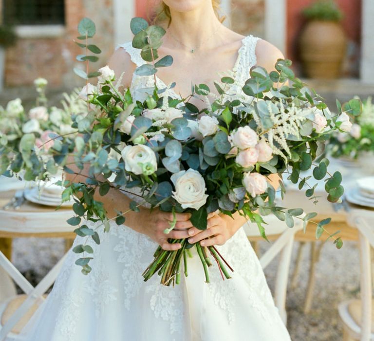 Bride in Lace Wedding Dress Holding a Romantic Wedding Bouquet with Eucalyptus, Ranunculus and Astilbe