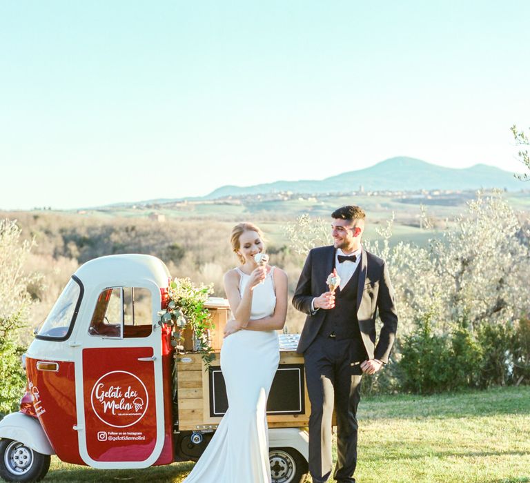 Bride in Lace Wedding Dress and Groom in Tuxedo Getting Ice-cream at a Gelato Truck