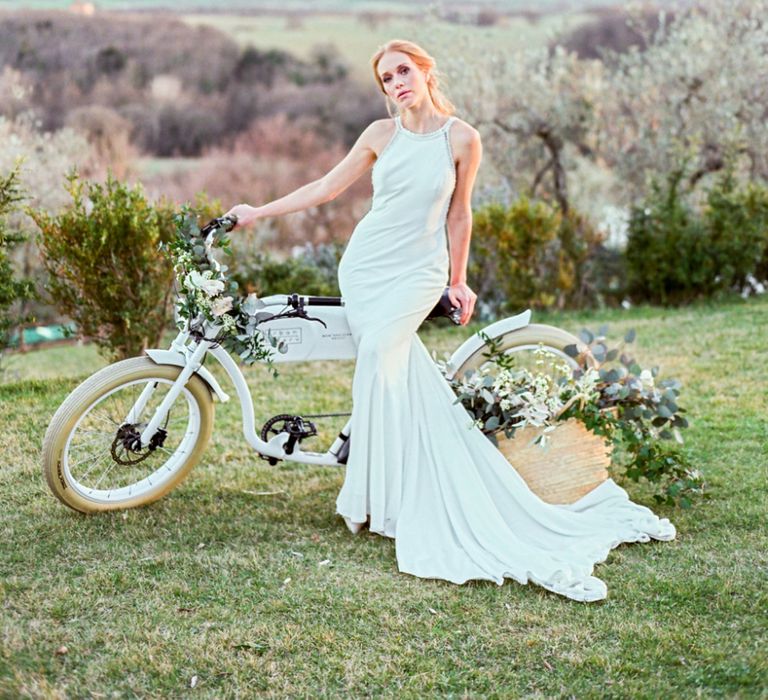 Bride in Lace Wedding Dress Standing Next to  a Vintage Bicycle