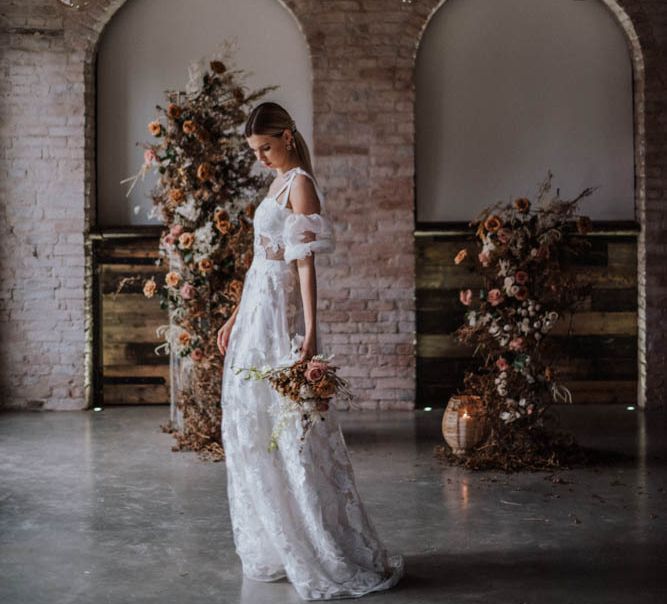 Bride in applique Emma Beaumont wedding dress standing in Iscoyd Park Coachhouse