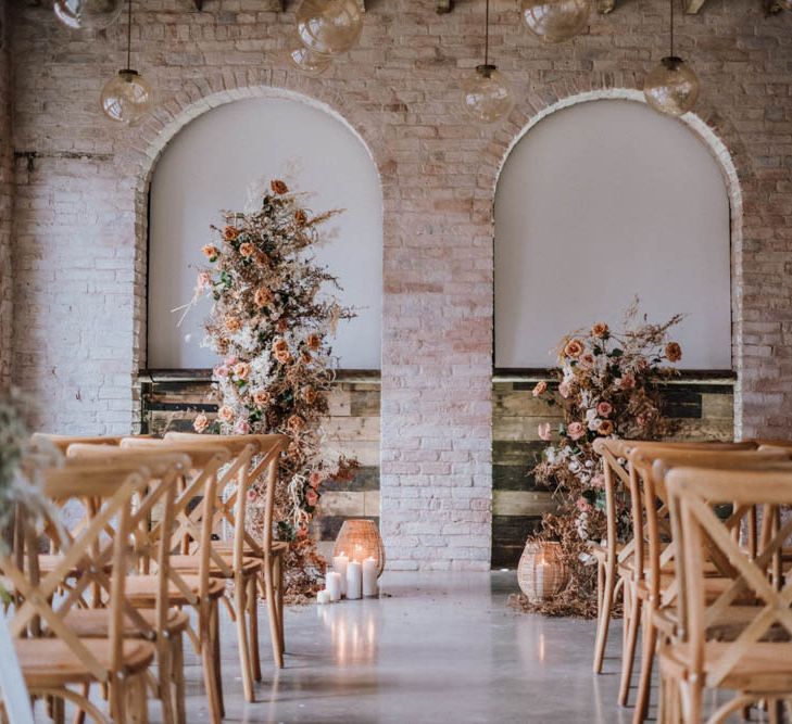 Ceremony setup at Iscoyd Park Coachhouse with wooden chairs and floral arrangements