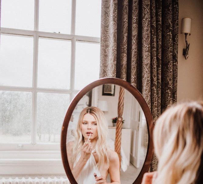 Bride applying her lipstick at Iscoyd Park wedding venue