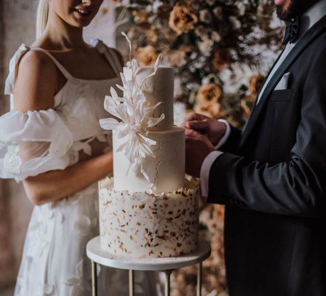 Bride and groom cutting the stylish wedding cake by Union Cakes