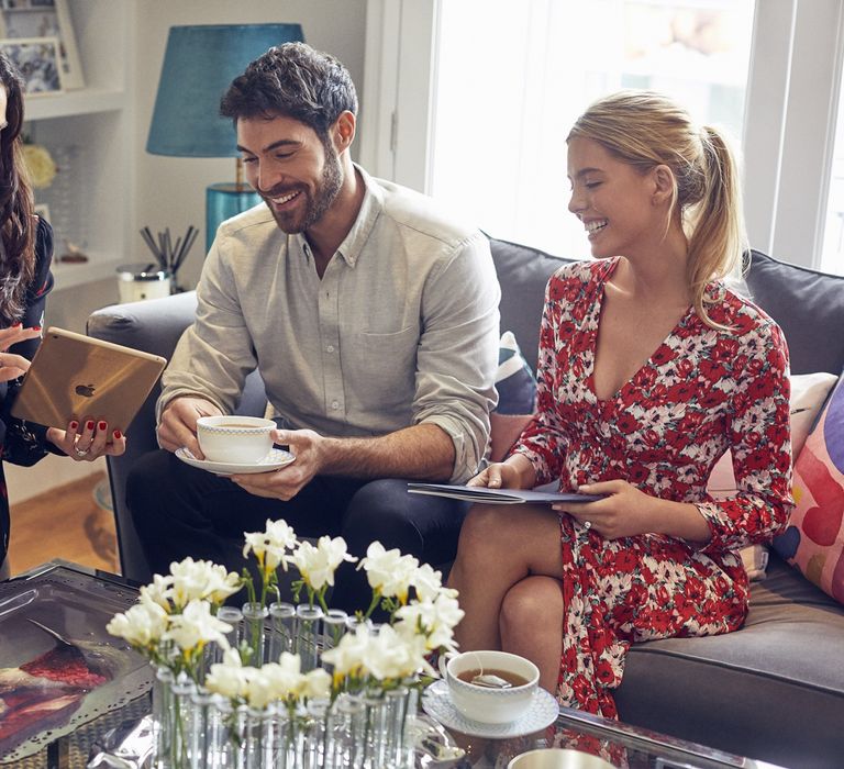 Couple with advisor in The Wedding Shop London Townhouse compiling their wedding gift list on an iPad