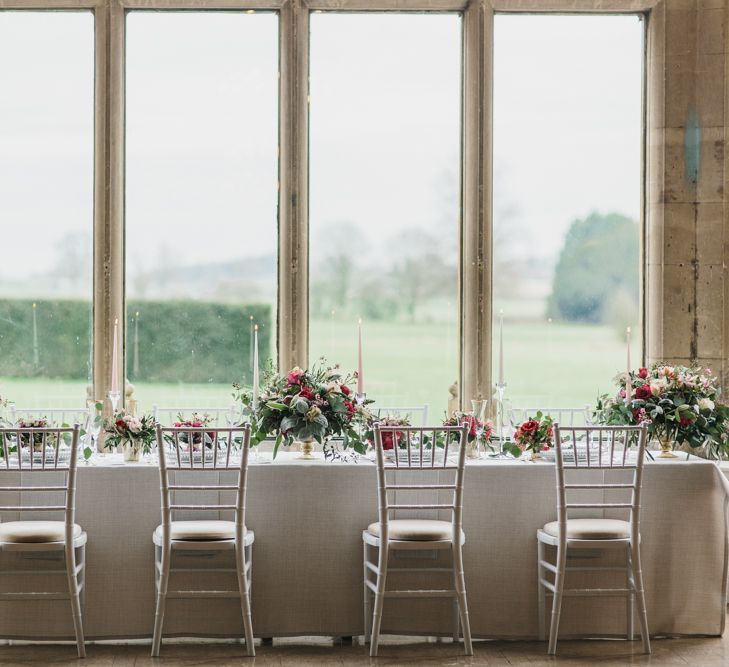 Reception Table with Taper Candles &amp; Low Floral Arrangements | Blush &amp; Burgundy Floral Fairytale Wedding Inspiration at Grittleton House Planned &amp; Styled by Jennifer Louise Weddings | Katherine Yiannaki Photography