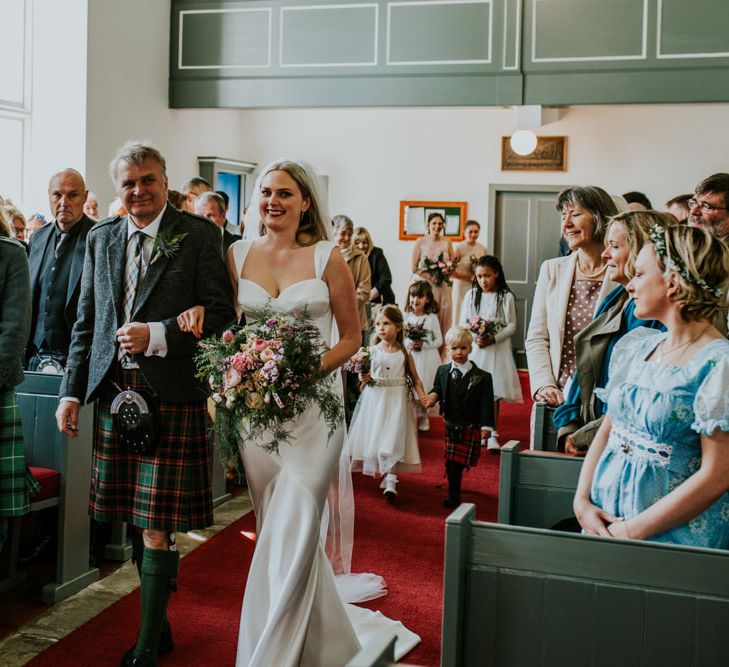 Bride walks down he aisle with father