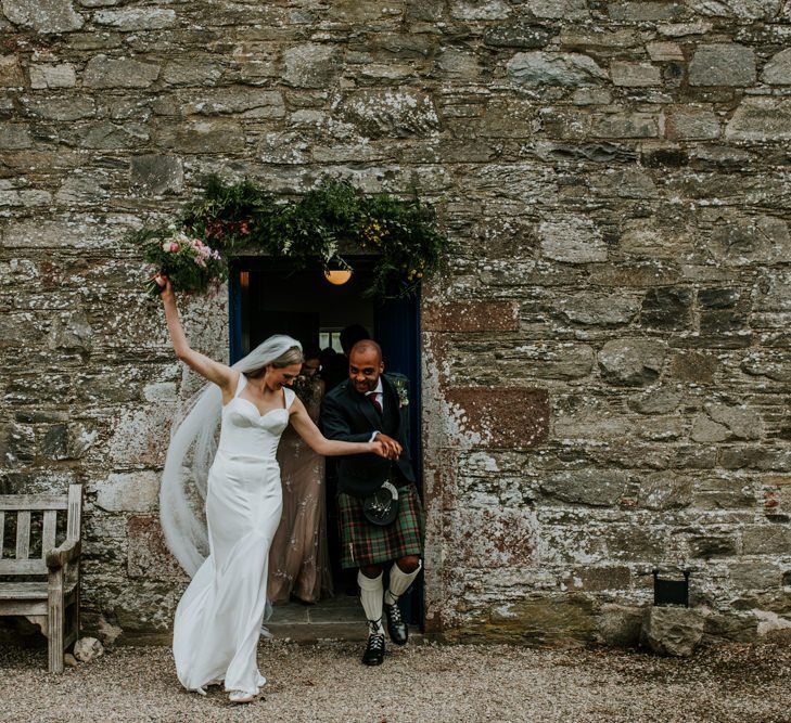 Bride and groom celebrate wedding with hanging flowers