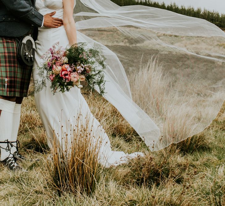 Bridal bouquet at wedding with hanging flowers