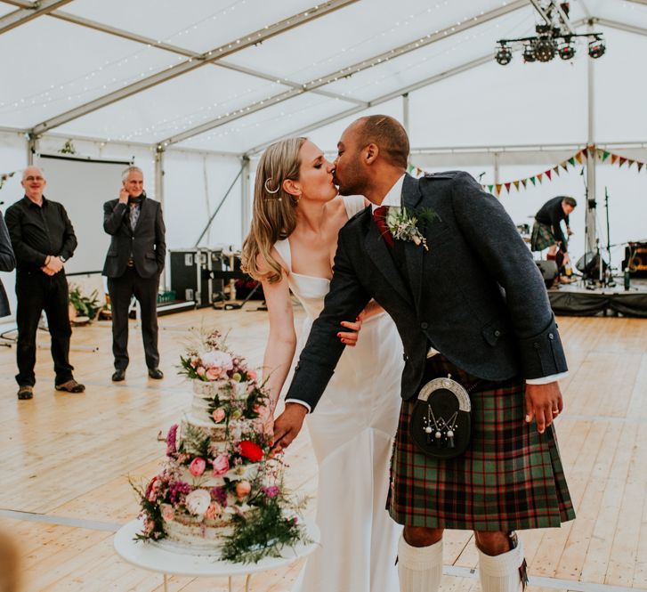 Bride and groom cut the floral wedding cake