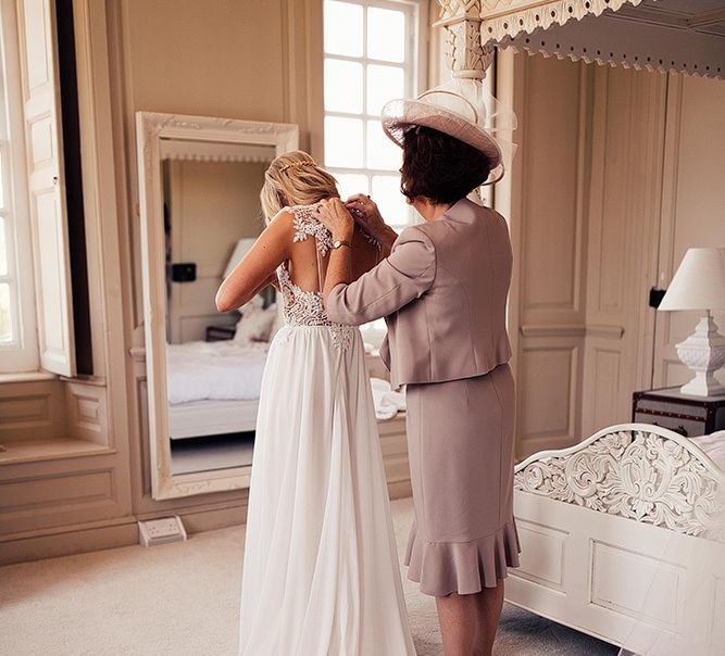 Bride on wedding morning putting on her Julio Vino wedding dress