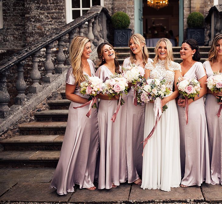 Bridal party portrait with bridesmaids in pink dresses and bride in a Julio Vino wedding dress for wedding with outdoor first dance