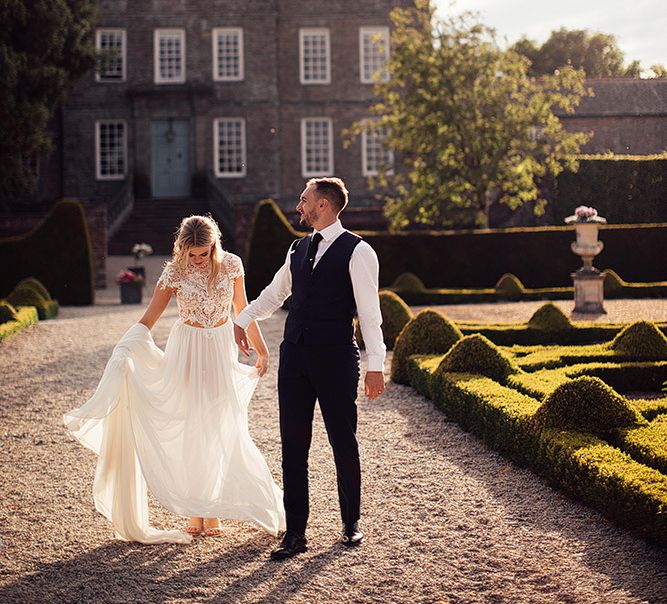 Portrait of bride in a Julio Vino wedding dress and groom in waistcoat for for wedding with outdoor first dance