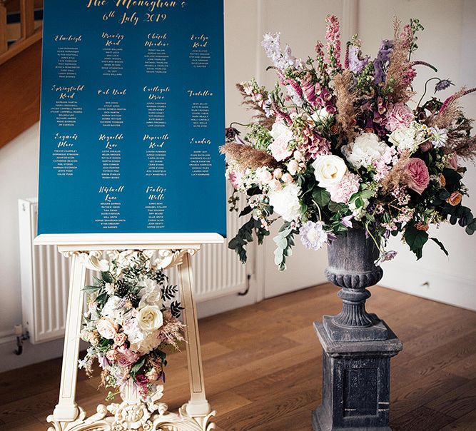 Seating chart on an easel and blush pink floral arrangement