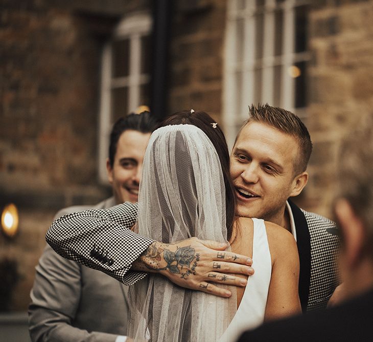 Wedding Guest Hugging Bride in Veil