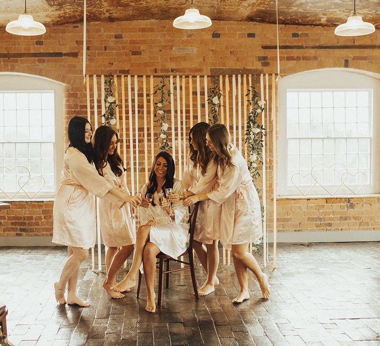 Bridal Party in Silk Getting Ready Robes Enjoying Champagne on the Wedding Morning