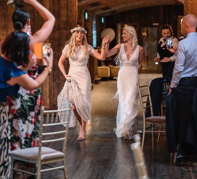 Brides enter wedding reception wearing Watters wedding dress