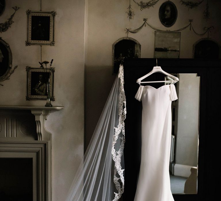 Raciela Pronovias Wedding Dress and Lace Edged Veil Hanging Up