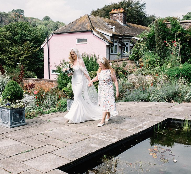 Mother of The Bride and Bride Holding Hands Walking to the Wedding Ceremony