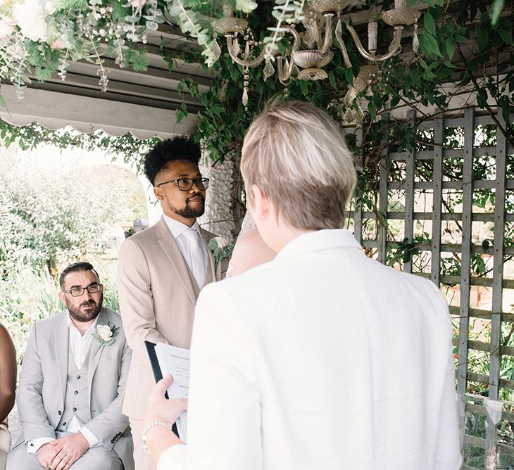 Bride and Groom Exchanging Vows with Their Witnesses Watching Them