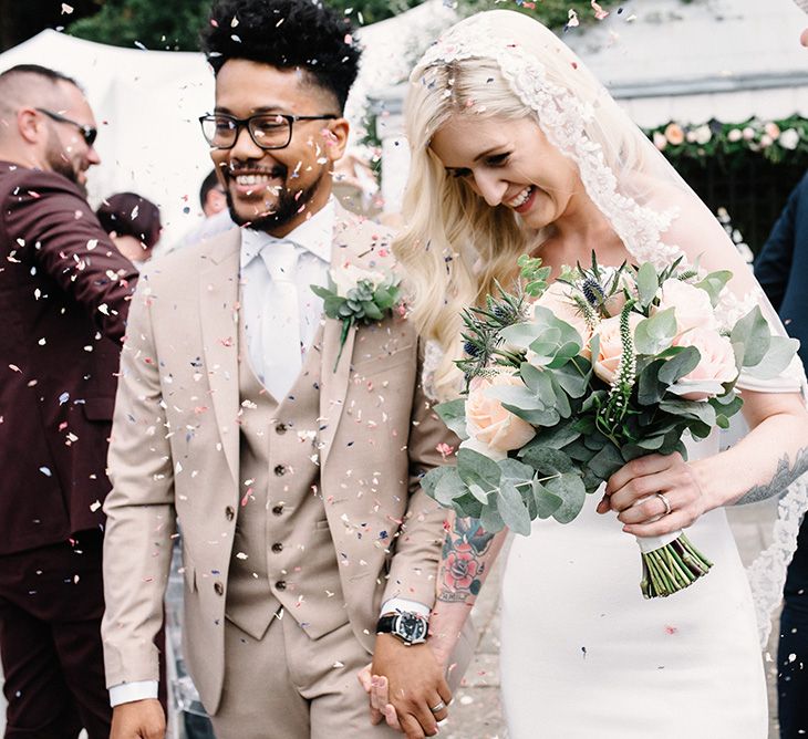 Happy Bride in Pronovias Wedding Dress and Groom in Beige Moss Bros. Suit