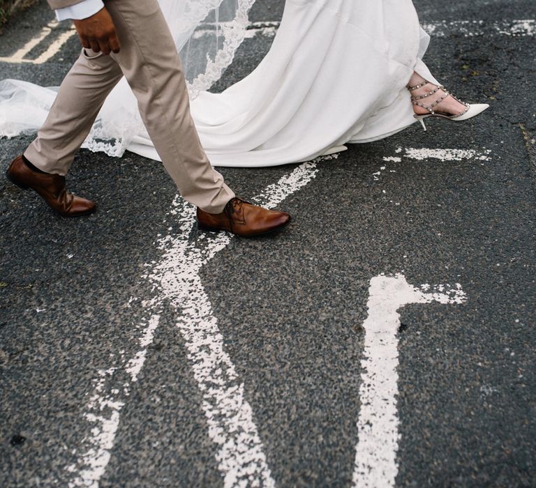 Bride and Groom Walking Across the Road with Bride in Valentino Rockstud Bridal Shoes