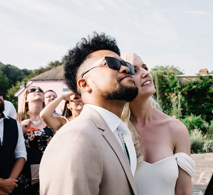 Bride and Groom Watching the Red Arrow's Fly By During Their Wedding Reception