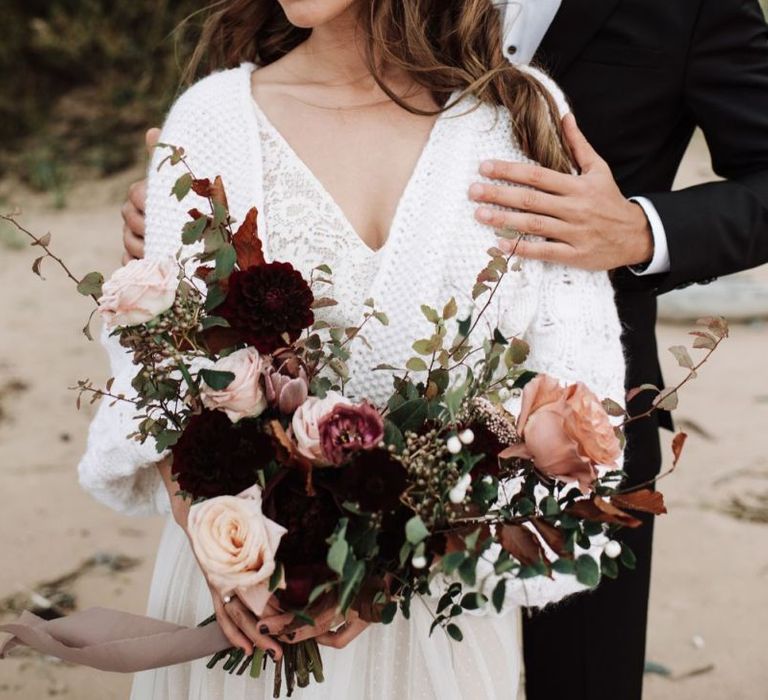 Beautiful Bride in Katya Katya Wedding Dress with Wool Coverup Holding a Deep Red and Pink Rose Wedding Bouquet