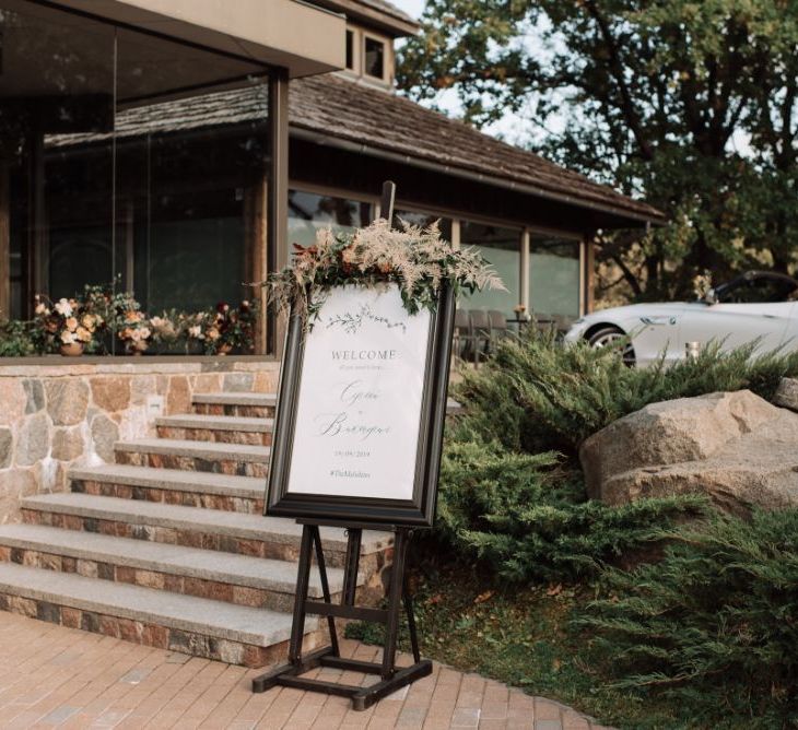 Black Framed Wedding Welcome Sign on an Easel Outside the Wedding Venue