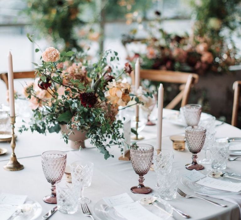 Wedding Reception Table Decor with Floral Centrepiece, Taper candles and Coloured Goblets